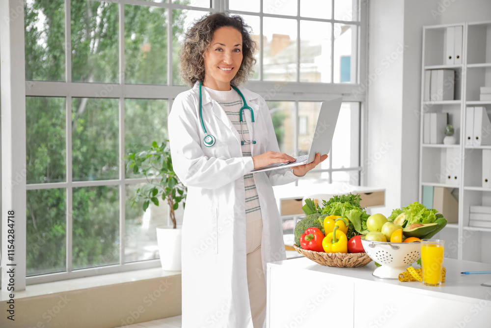Mature female nutritionist working with laptop in office
