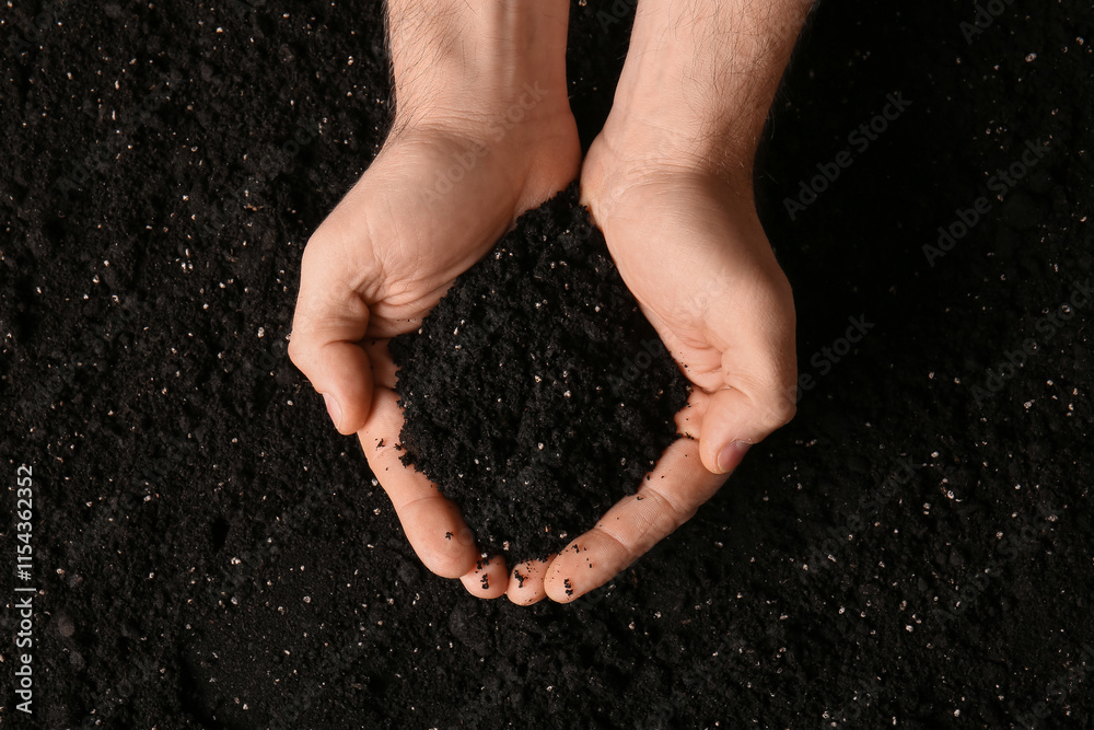 Female hands with black soil, closeup