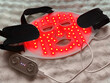 © New Africa - Led light therapy face mask on soft fabric, above view. Beauty treatment