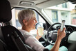 © Davor - Senior nurse texting on smartphone while on coffee break in car