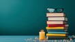 © Gefo - Creative and cozy arrangement of colorful books with glasses and a glowing candle against a serene green background