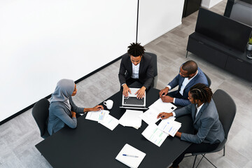 Aufkleber - Business meeting with diverse professionals discussing documents and using a laptop.