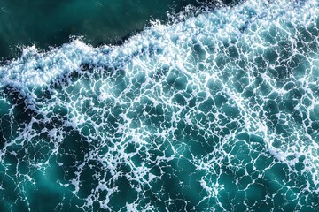 Poster - Aerial view of ocean waves creating intricate foam patterns on turquoise water surface.