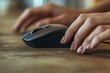 © ceoJAHID - Closeup of a female hand using a computer mouse on a wooden table