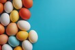 © YURIMA - A vibrant and colorful display of Easter eggs meticulously arranged against a beautiful turquoise background, radiating pure joy and celebrating the cheerful spirit of spring and fresh new beginnings