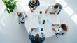 © fotofabrika - Group of professionals engaged in a collaborative meeting around a round table in a modern office environment