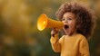 ©  lukaPixMedia - A cheerful child with curly hair joyously shouts into a bright yellow megaphone, capturing the essence of childhood exuberance and the spirit of communication and play.