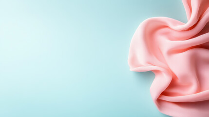 Poster - Soft pink fabric draping elegantly on a light blue background creating a serene atmosphere