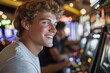 © Milos - A smiling young man is engaged with a slot machine, showcasing joy and excitement in a bustling casino, representing the thrill and entertainment of gaming culture.