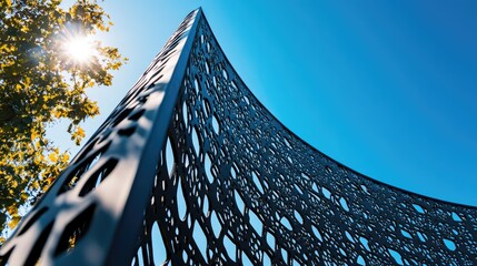 Poster - Modern architectural design featuring detailed iron lattice work against a bright blue sky with sunlight and greenery in the frame
