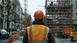 © EFA - Construction worker observing a building site with cranes and scaffolding.