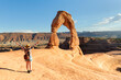 © xamnex - Woman looking at the Delicate Arch in Arches National Park, United States