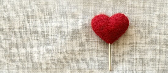 Poster - red heart pin on a soft neutral fabric background with ample empty space for text or branding elemen