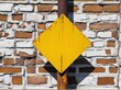 © Татьяна Кузнецова - Yellow diamond road sign against a textured brick wall in daylight