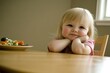 © Halina Berah - The young girl is eating her vegetables but expresses unhappiness with her meal. Providing nutritious food to a child poses some difficulties.