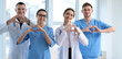 © Pixel-Shot - Team of doctors making hearts with their hands in clinic