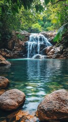 Wall Mural - Majestic waterfall cascading into clear blue pool surrounded by rocky terrain in a serene landscape