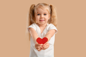 Wall Mural - Cute little girl with heart on beige background. Valentine's Day celebration