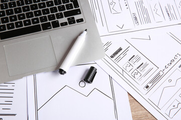 Leinwandbilder - Developing UI design. Sketches of website wireframes, laptop and felt pen on wooden table, above view