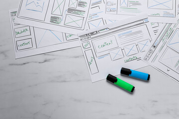 Leinwandbilder - Developing UI design. Sketches of website wireframes and felt pens on white marble table, top view