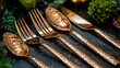 © mochalfin - Close-up of elegant copper hammered-texture flatware set on dark background with green foliage.