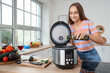 © Pixel-Shot - Young woman pouring olive oil into multi cooker in kitchen