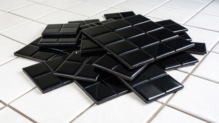 Poster - A vivid image of glossy black tile spacers piled together on a stark white floor the contrast creating a striking visual impact.