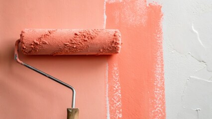 Poster - A painters roller covered in a thick layer of light coral paint resting against the wall where the vibrant color drapes over the previously dull surface.