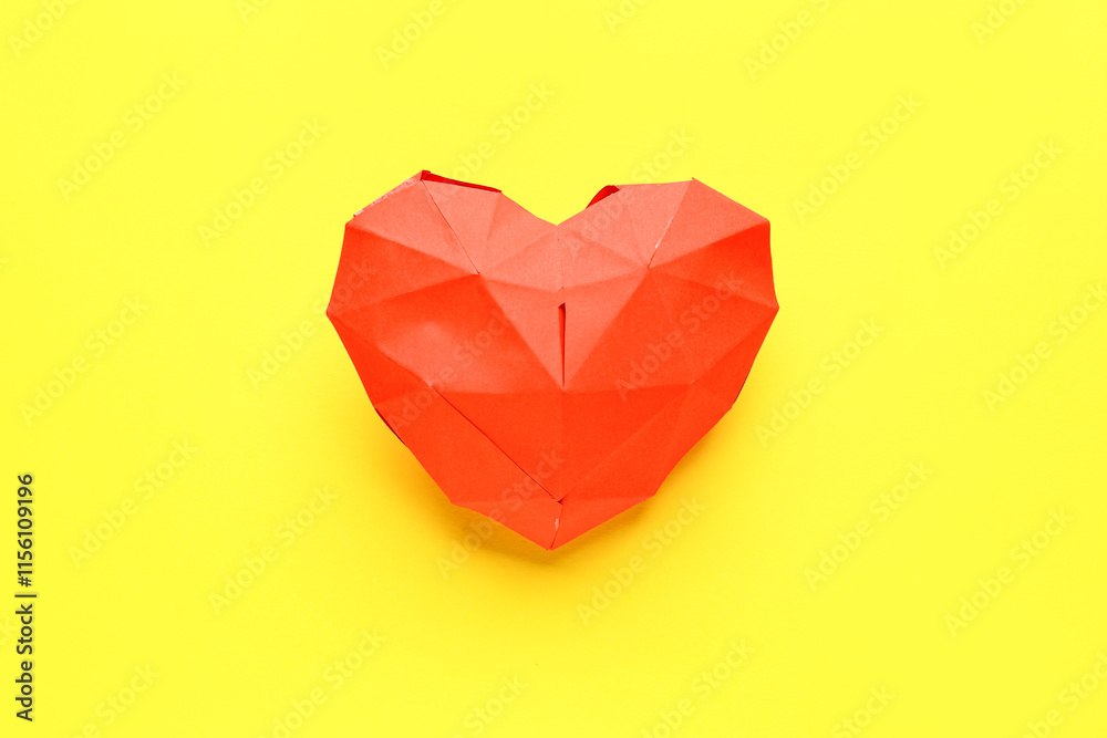 Red heart made of paper on yellow background. Valentine's Day celebration