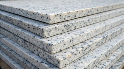 Poster - A closeup perspective of a stack of speckled gray and white marble slabs