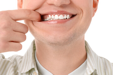 Smiling young man with healthy teeth on white background, closeup