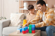 © Pixel-Shot - Happy father and his little son playing with cubes at home