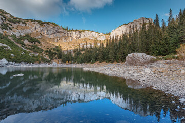 Wall Mural - Beautiful mountain lake reflecting surrounding rocky peaks and lush pine forest in Durmitor National Park, Montenegro