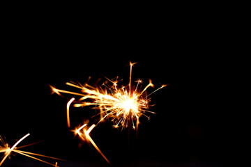 Wall Mural - a sparkler is a type of hand held firework that burns slowly while emitting bright colored sparks