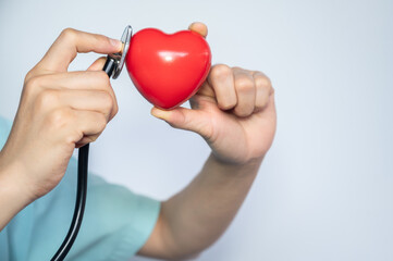 Wall Mural - Cropped shot view of someone holding a rubber red heart with Stethoscope. Conceptual shot of medical condition.