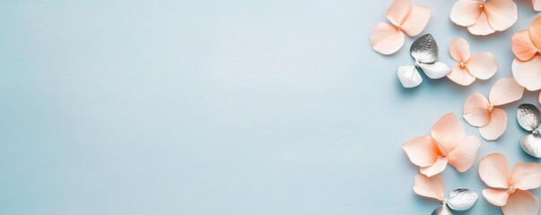 Poster - Pastel floral concept. Delicate flower petals arranged on a soft blue background, creating a serene atmosphere.