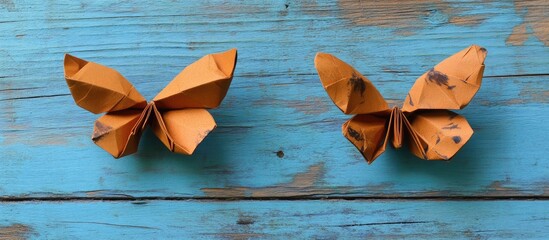 Poster - Couple of origami butterflies crafted from coffee paper displayed on vibrant blue wooden boards