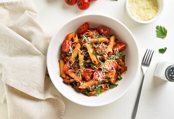 Wall Mural - Bowl of bolognese penne pasta with minced meat, tomatoes and greens