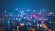 © Teeraphon - Smart digital Innovation city with connection network reciprocity over the cityscape. of future smart wireless digital city and social media networking systems that connects people with in city