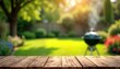 © Pete - Wooden table top outdoors in sunny garden. Empty tabletop ideal for product display. Blurred background shows backyard setting with grill BBQ, green grass. Summer spring day. Relaxing atmosphere.