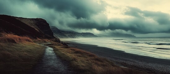 Poster - Serene coastal pathway under dramatic skies with rolling waves and cliffs in the distance showcasing natural beauty and tranquility.