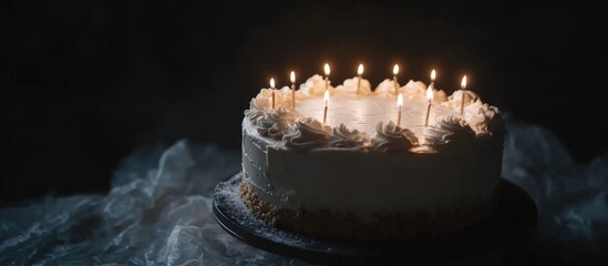 Aufkleber - Elegant white cream cake adorned with lit candles set against a dark background creating a celebratory atmosphere for special occasions.