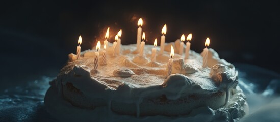 Aufkleber - Festive white cream cake adorned with lit candles set against a dark background creating a warm celebratory atmosphere.