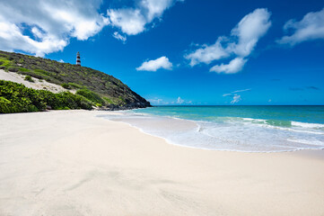 Wall Mural - Lighthouse is on a hill overlooking the ocean