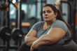 © NBLX - Smiling plus size woman in sportswear exercising in the gym. Concept of body positive, weight loss.