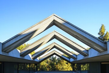 Fototapete - An abstract architectural roof design with geometric frames against a bright blue sky, featuring a blend of modernity and creativity with nature's complement.