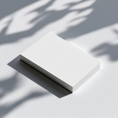 Poster - Blank Business Cards Resting on a Light Surface, Showcasing Shadows and Textures During Afternoon Sunlight