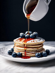 Poster - A stack of pancakes, drizzled with syrup, sprinkled with fresh blueberries and powdered sugar on a white plate.
