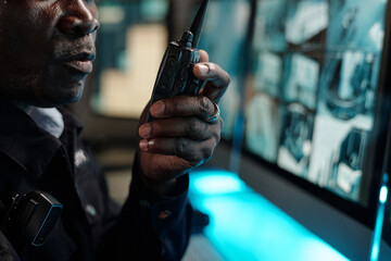 Poster - Hand of mature male guard speaking in walkie-talkie in front of computer screen while reporting about situation in hotel