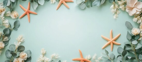 Poster - pentagonal frame with eucalyptus leaves paper flowers and wooden starfish on mint background ideal f
